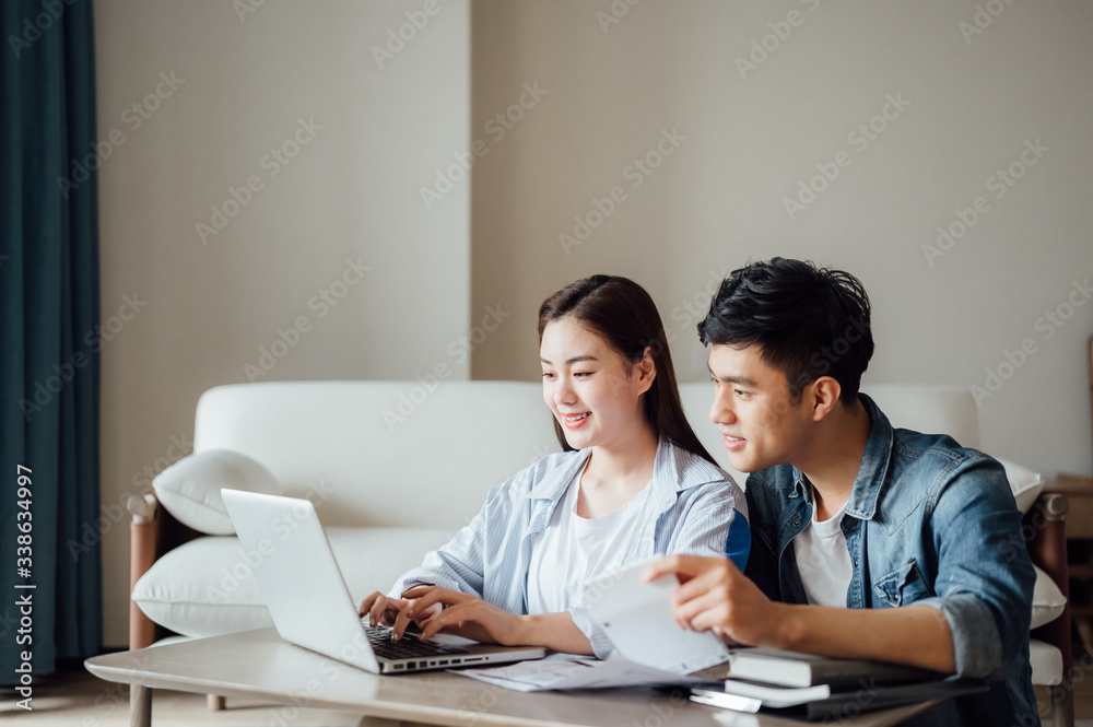 Young Asian couple at home using computer Young Asian couple at home using computer