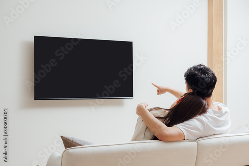 Young Asian couple at home watching TV photo