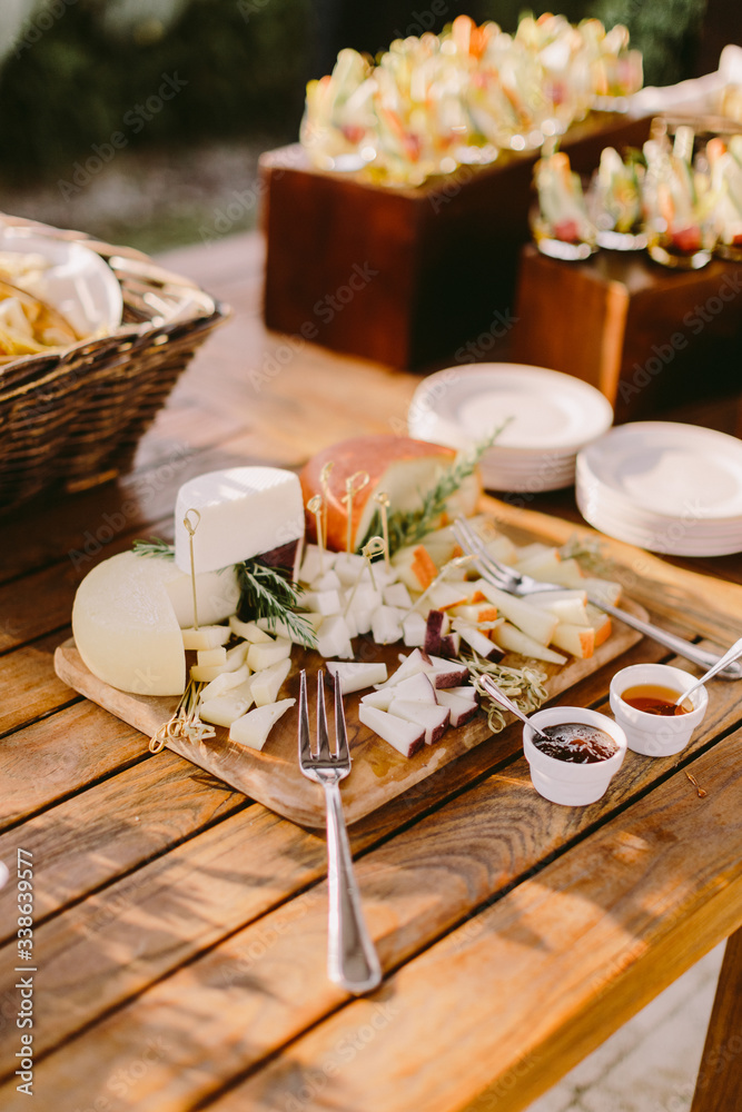 cheese platter with different sorts of cheese and jam on wooden table. Italian food style. 