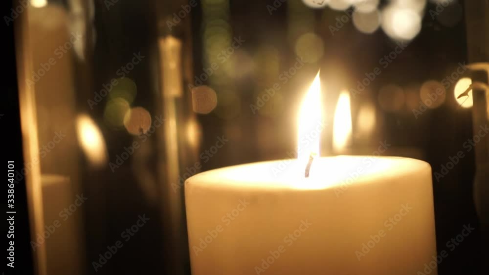 Beautiful fire of a candle outdoor, a warm yellow candle quietly burning in the dark. Beautiful fire of a candle outdoor, a warm yellow candle quietly burning in the dark.