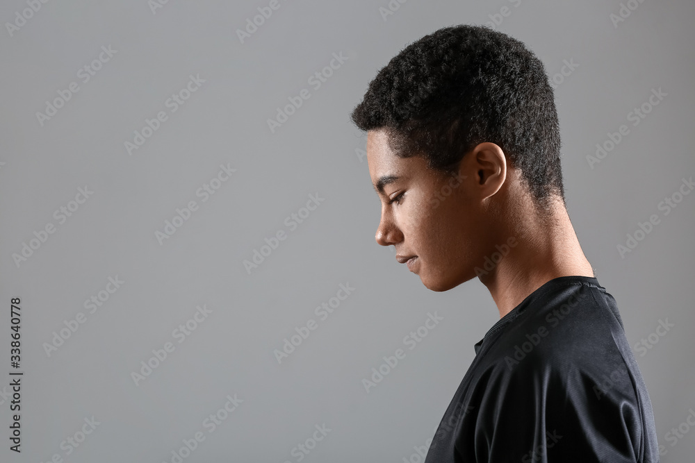 Young African-American football player on grey background Young African-American football player on grey background