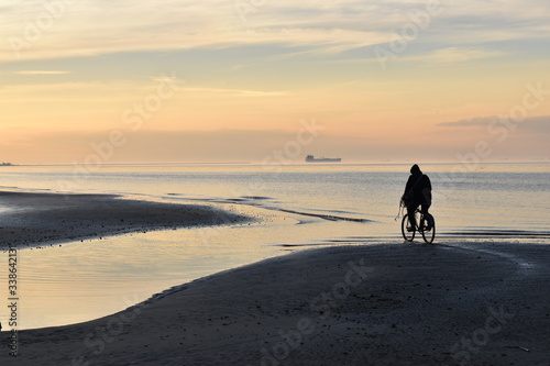 pedalear en bicicleta en la playa al atardecer en el Río de la Plata, Berisso, Argentina