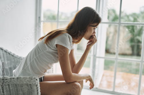 young woman sitting on window sill