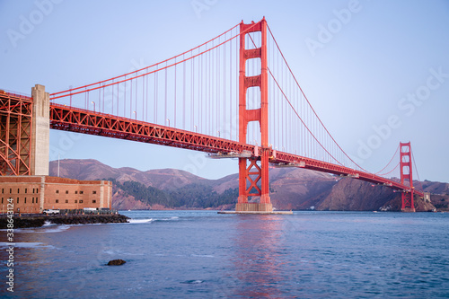 The famous Golden Gate Bridge in San Francisco, California. Beautiful sunlight hitting the bridge as cars drive over it. 