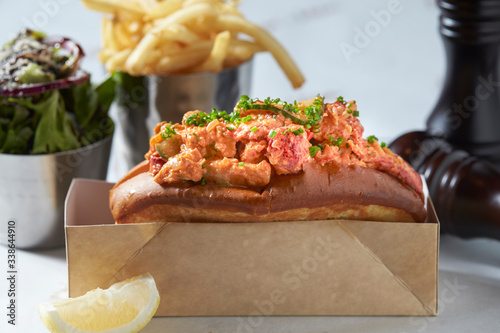 lobster roll on slate surface and burger photo