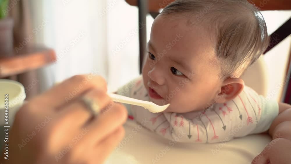 mother feeding baby. asian woman feed her baby at home mother feeding baby. asian woman feed her baby at home