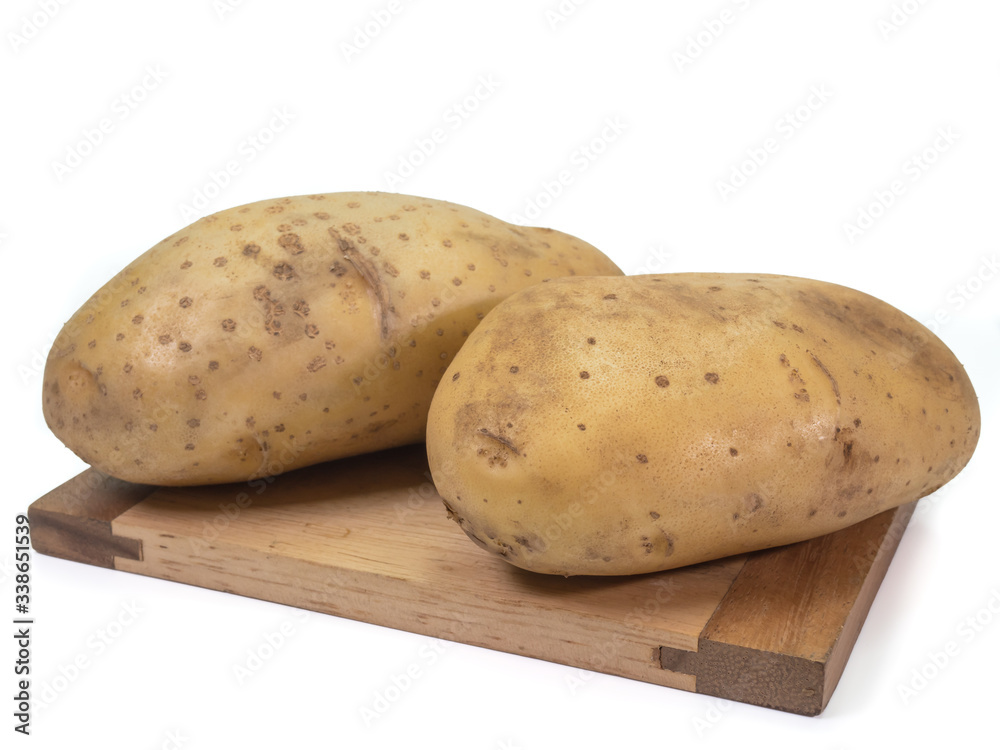 The close up of fresh organic potato vegetable on small wooden board on white background.