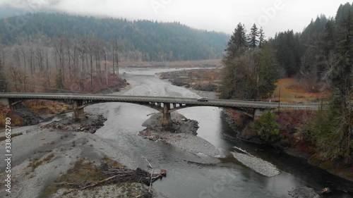 Retreating tracking aerial: Vehicle crosses old bridge on Elwha River photo