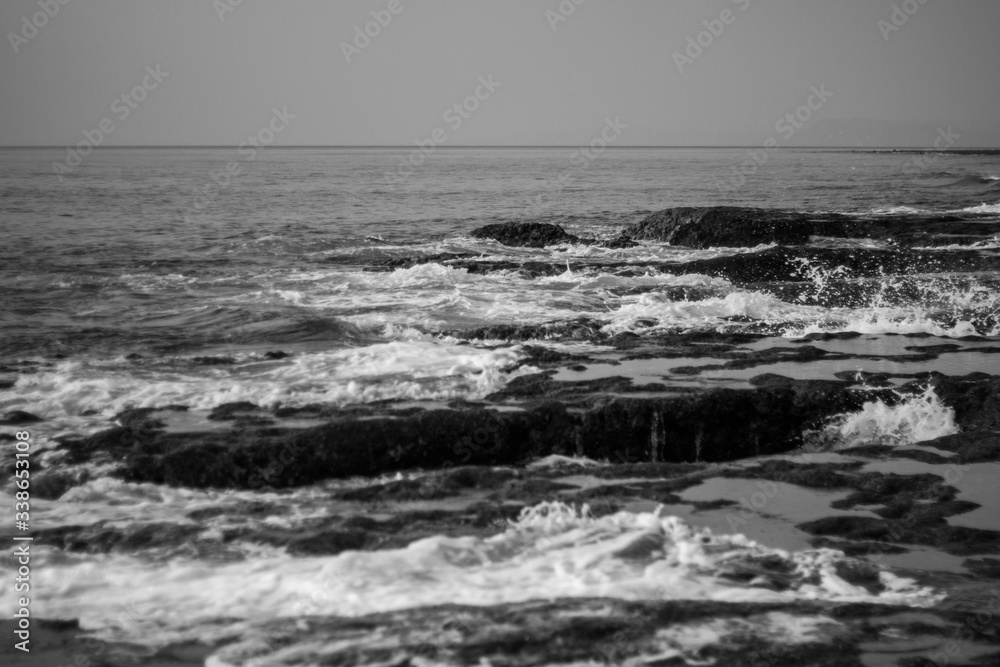 A black and white shot of the Indian Ocean waves crashing on Rocky beach of Neil Island