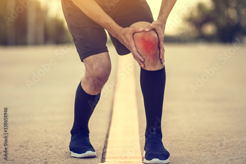 Runner man hand hold knee pain ankle painful running on evening,