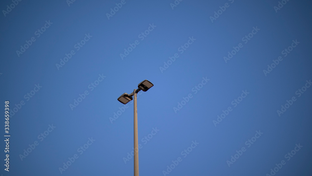 A light in a parking lot on a clear day A light in a parking lot on a clear day
