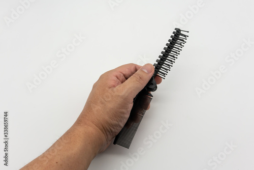 Two ways folding hair brush pocket comb. Black fish bone shape comb isolated on white