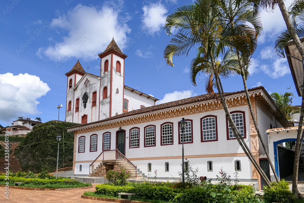 Wonderful decorated colonial building and a church in background at historical town Serro on a sunny day, Minas Gerais, Brazil