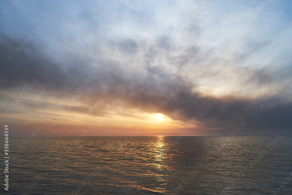 Fototapeta premium Sea sunset. Smoke wildfires sweeping across the sky.