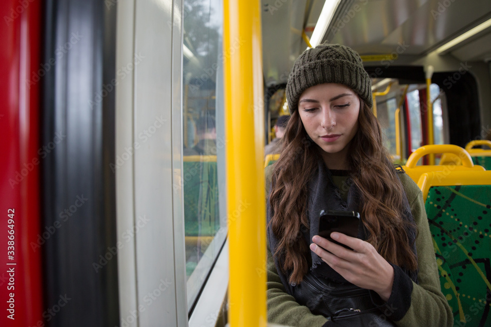 Fototapeta premium Young Woman Texting While She Rides the Melbourne Tram
