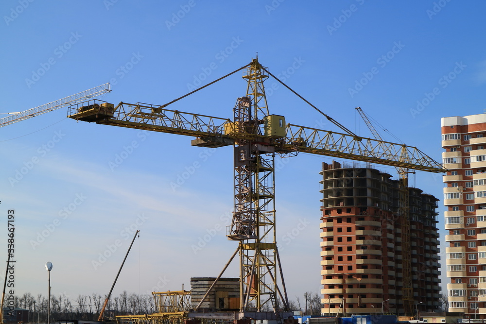 Tower cranes are working on the construction of a new house. Lifting crane.