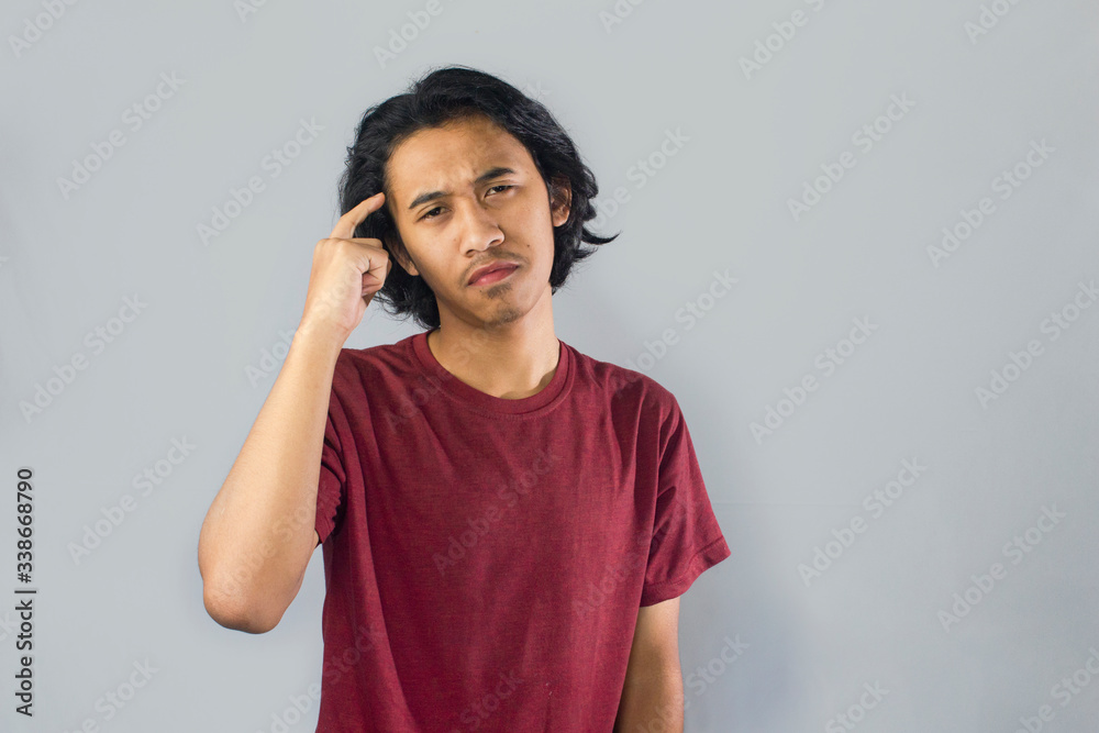 Young asian men with smart thinking gesture, finger touch forehead,isolated background. seective focus. Young asian men with smart thinking gesture, finger touch forehead,isolated background. seective focus.