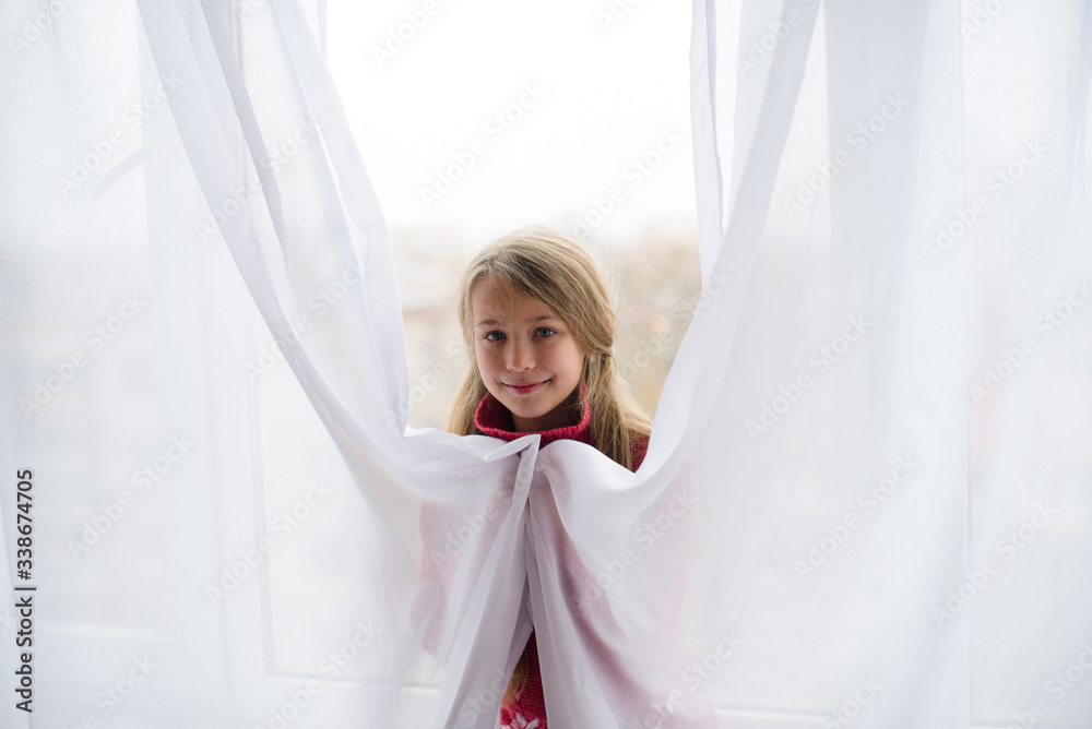 girl hiding behind window white transparent curtain in afternoon. Quarantine home girl hiding behind window white transparent curtain in afternoon. Quarantine home