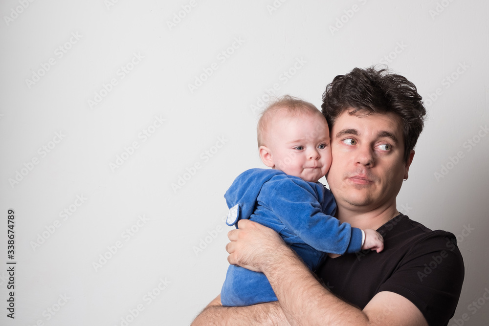 Young dad with a baby. Selective focus. Cute dad is played with a baby. Young dad with a baby. Selective focus. Cute dad is played with a baby.