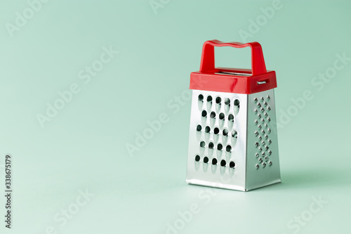 One single cheese grater on a green background