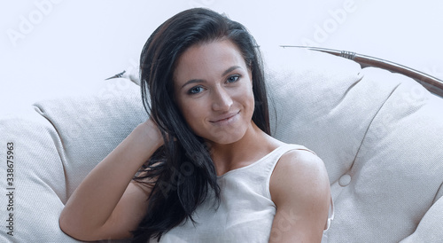 Modern young woman relaxing in a round cozy soft chair