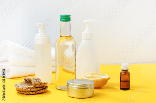 Set of eco-friendly natural cleaning products on yellow kitchen table: soda, essential oils, cellulose sponge, rags, lemon, soap, vinegar. Zero waste, eclogical habbits