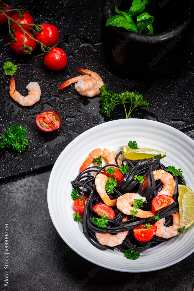 Squid Ink Pasta With Seafood, Herbs, Cherry Tomatoes. Black Spaghetti, Black Organic Noodles with Shrimps. Mediterranean gourmet food.