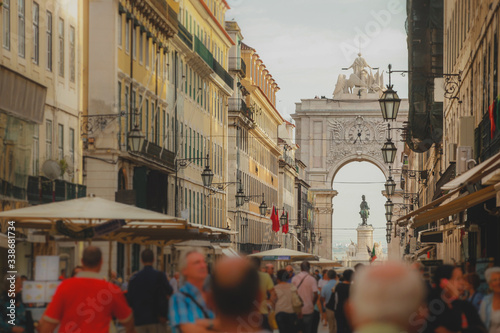 Rua Augusta with the well known arch or Arco da Rua augusta with crouds of tourists looking by on a summer day in Lisbon, Portugal. photo