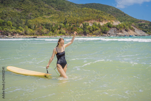 Beautiful young woman ride wave. Sporty surfer woman surfing on the background of blue sky, clouds and transparent waves. Outdoor Active