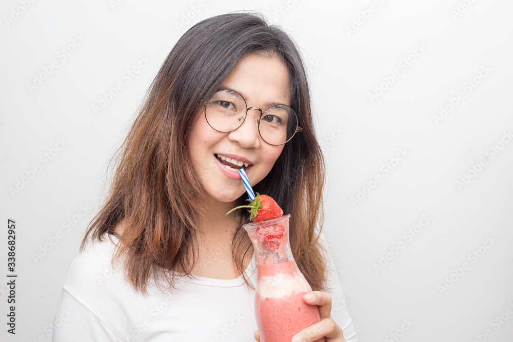 Women drinking homemade strawberry smoothies with fresh fruit on white background Women drinking homemade strawberry smoothies with fresh fruit on white background