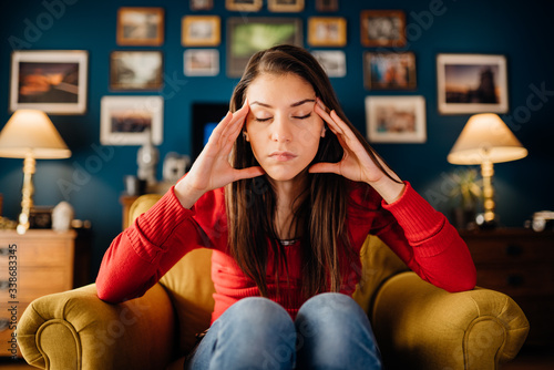 Stressed woman overthinking events alone at home.Thinking of problems.Concentration problems.Brain/cognitive/neurological activity stimulation.Memory loss.Headache,migraine,high blood pressure,anxiety photo