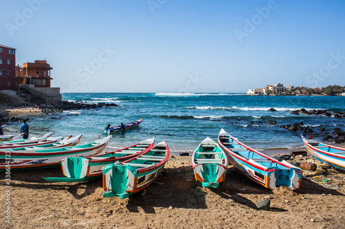Fishing boats in Ngor Dakar, Senegal, called pirogue or piragua or piraga. Colorful boats used by fishermen standing in the bay of Ngor on a sunny day. photo