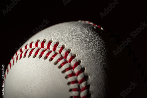 A white leather baseball on a black background