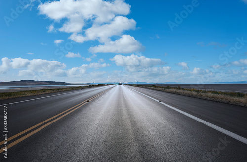 Autostrada verso l'orizzonte con cielo azzurro e qualche nuvola © Francesco