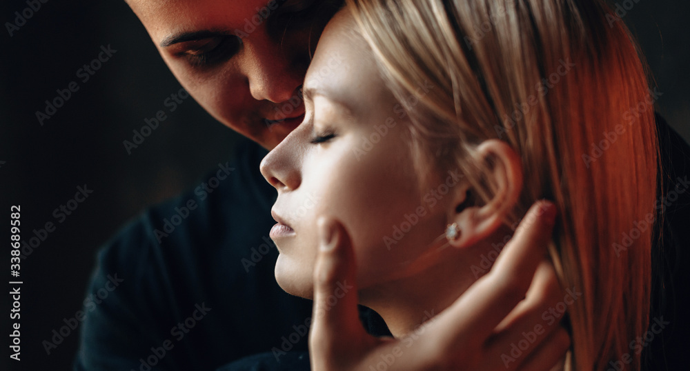 Close up view of a charming caucasian couple embracing and touching each other in a nice evening