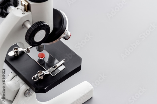 Research with microscope. Laboratory backround with blood sample on grey table copy space