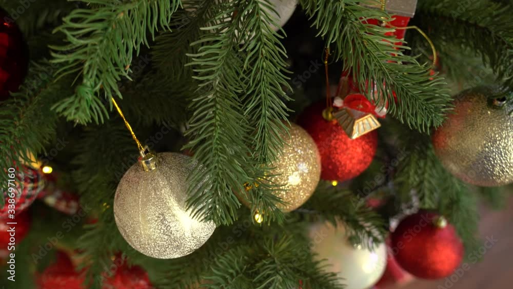 Closeup view 4k video of green branches of pine Christmas tree decorated with many round red and gold colors holiday balls. Closeup view 4k video of green branches of pine Christmas tree decorated with many round red and gold colors holiday balls.