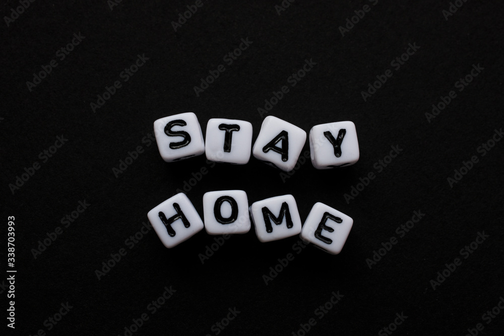 Obraz premium Stay Home, Word written by Cube letters, Stop Corona Virus, Message for people white cubes on a black background, no person, space for text and horizontal