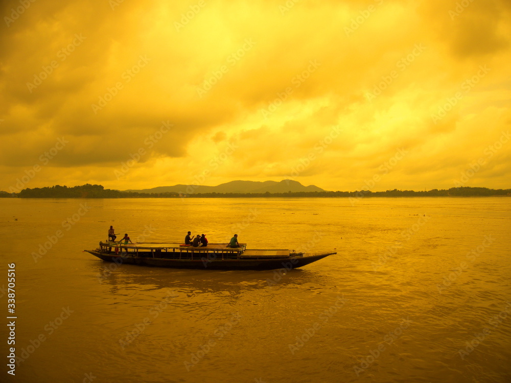 Boat sailing at river brahmaputra during sunset