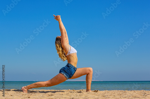 Young dutch woman in yoga posture on beach