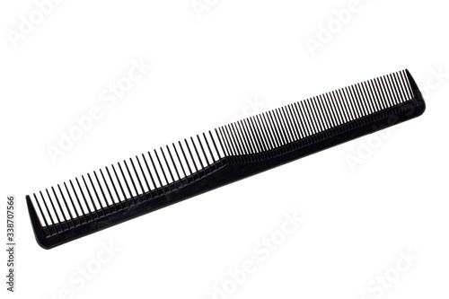 Hairdresser tools isolated. Close-up of a black hair comb isolated on a white background. Equipment of hair stylist. Macro photograph.