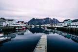 henningsvaer harbour with boats on the side and mountain in background