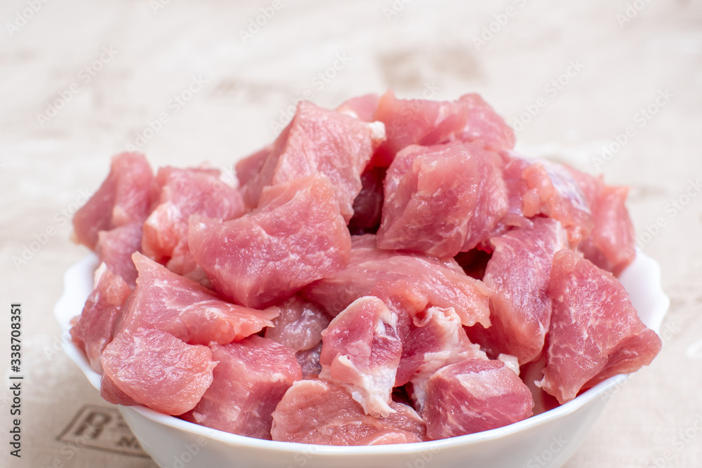 Close up sliced raw meat in a white bowl on a light table