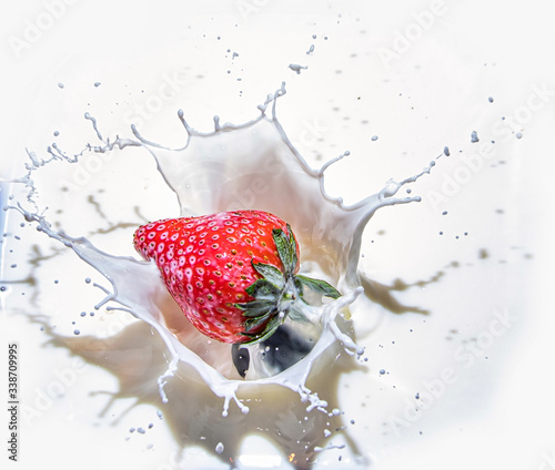 strawberry falling into milk splash