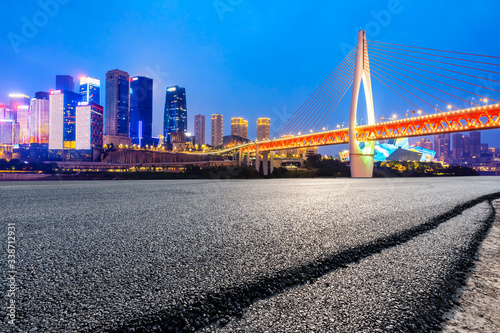 Empty asphalt road and city skyline with buildings at night in Chongqing,China.