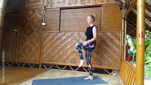 young blond woman doing yoga posture dancer in slow motion