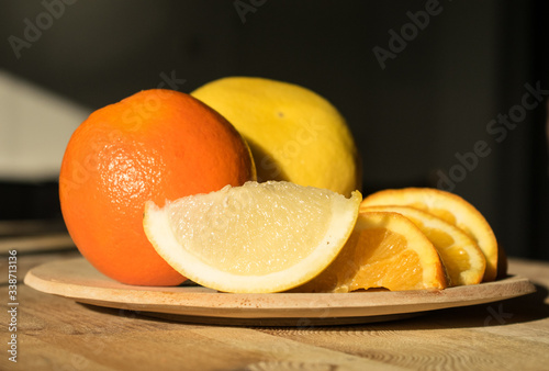 Slices of tropical fruit on a wooden plate in the morning sun