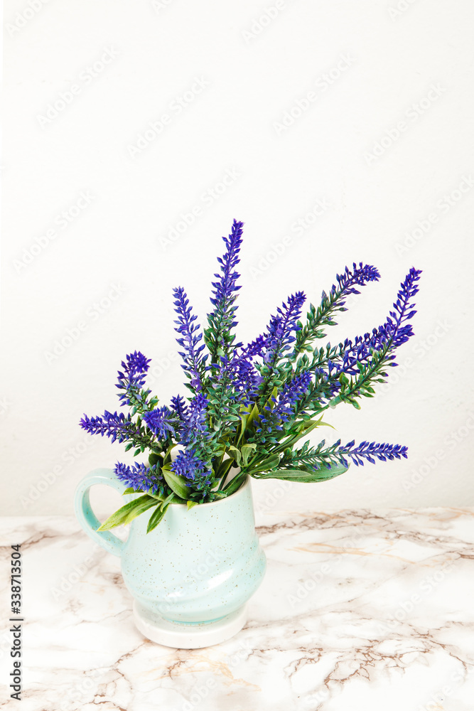 Lavender flowers in a mug on a marble table - obrazy, fototapety, plakaty 