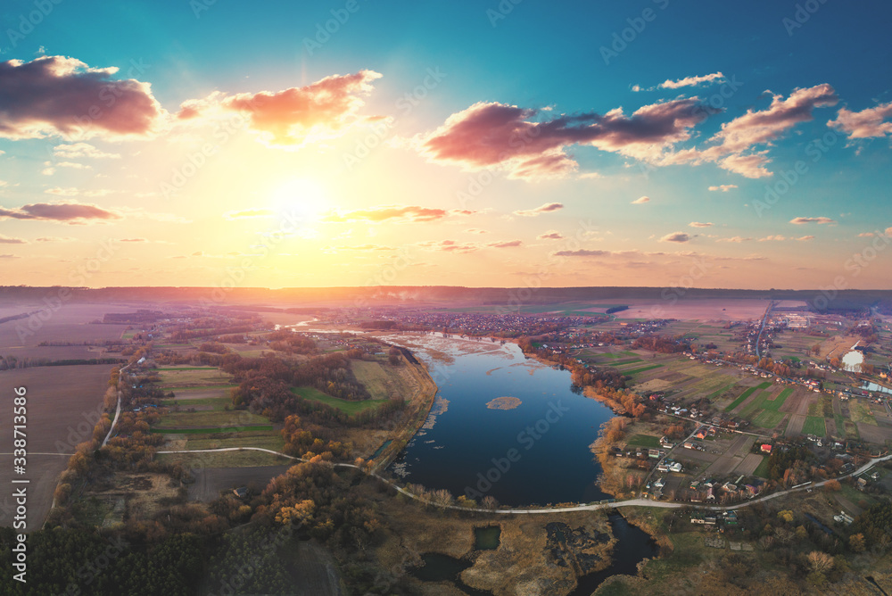 Naklejka premium Spring rural landscape in the evening, aerial view. Panoramic view of the river on the meadow at sunset. Panorama from 9 images