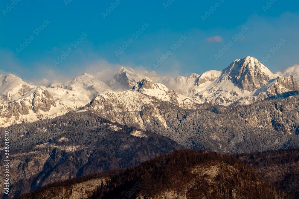 Julian alps covered in morning mist, view from Bohinj, Slovenia